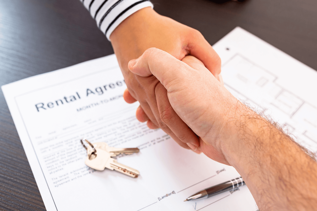 People shaking hands over a rental agreement contract